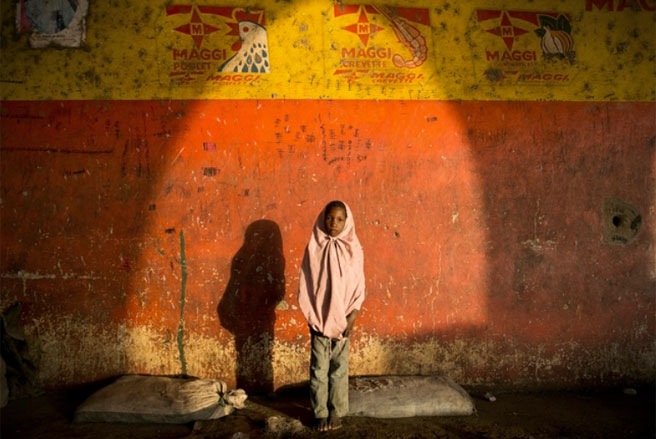 Em Aisha Abdoulaye, 6 tuổi, chụp ảnh ở khu chợ cá nơi em làm việc tại Gao, Mali, hồi tháng 2/2013 - Tin: WSJ/Ảnh: EPA.