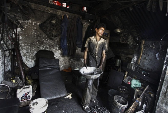Một cậu bé làm việc trong một xưởng cơ khí ở Srinagar, Ấn Độ vào tháng 6/2013 - Tin: WSJ/Ảnh: EPA.