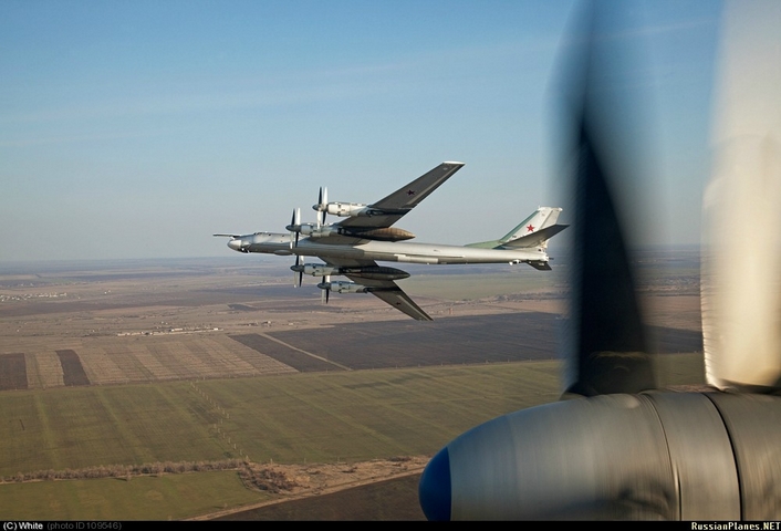 Máy bay ném bom chiến lược Tu-95MS liệng cánh trên cánh đồng.