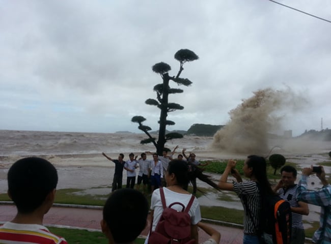 Nhiều người tranh thủ tạo dáng, chụp hình ngay trước các cột sóng đang đánh vào bờ.