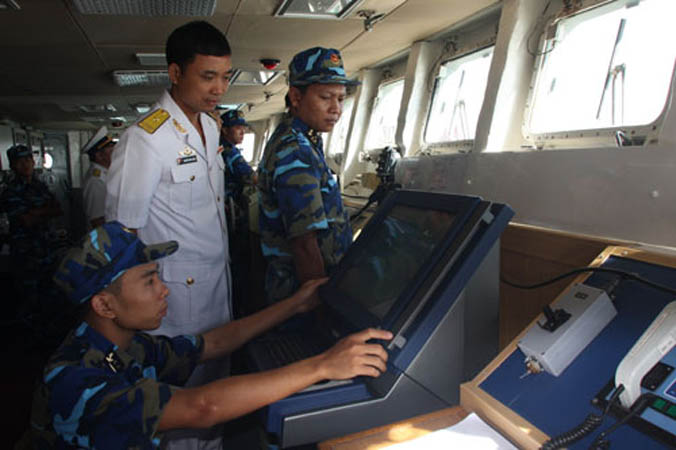 Sau cuộc tuần tra, biên đội tàu của Hải quân Việt Nam bắt đầu tiến vào lãnh hải Trung Quốc. Trong ảnh: Thiếu tá Nguyễn Đình Giảng - Thuyền trưởng HQ-011 - đang chỉ huy tổ lái điều khiển tàu vào cảng Trạm Giang