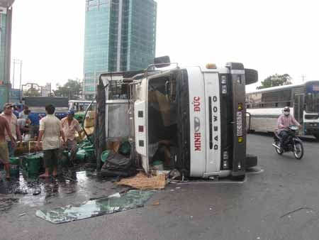 Trong lúc hỗn loạn, lực lượng CSGT phải điều tiết giao thông và khắc phục hậu quả vụ tai nạn, còn hàng trăm người dân địa phương đã tranh thủ ra hôi của là những thùng dầu bị đỏ ra thành vũng trên đường.