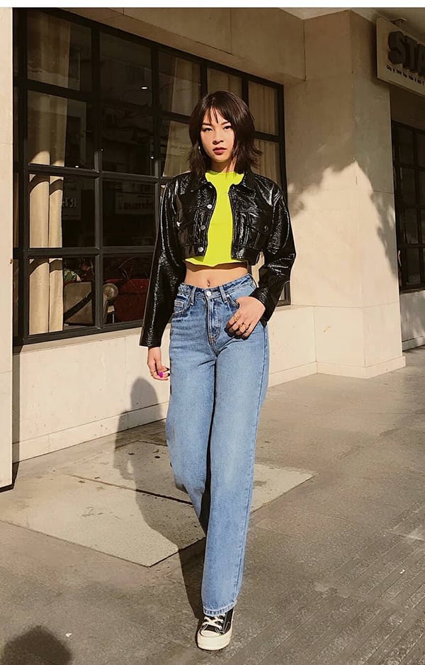 Phí Phương Anh mặc kiểu quần jeans cổ điển kết hợp cùng áo crop vàng tươi, áo khoác da đen bóng.    