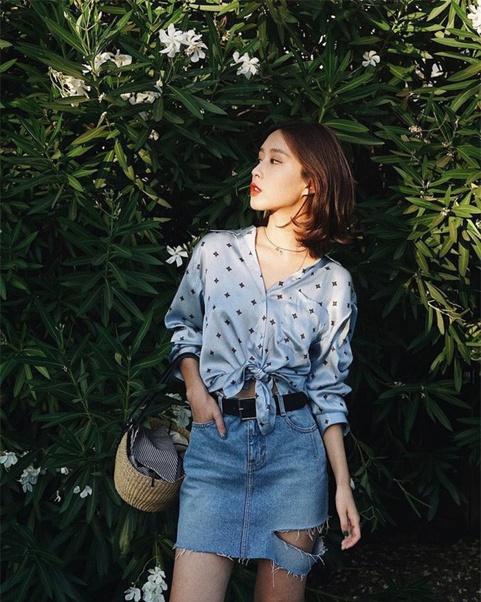 Set đồ này là sự pha trộn tuyệt hay giữa nét gợi cảm của chiếc sơ mi lụa bóng buộc vạt với vẻ cá tính, nghịch ngợm của chân váy denim rách. Diện cả set lên mình, vẻ ngoài của các nàng sẽ trở nên ấn tượng và sành điệu vô cùng.