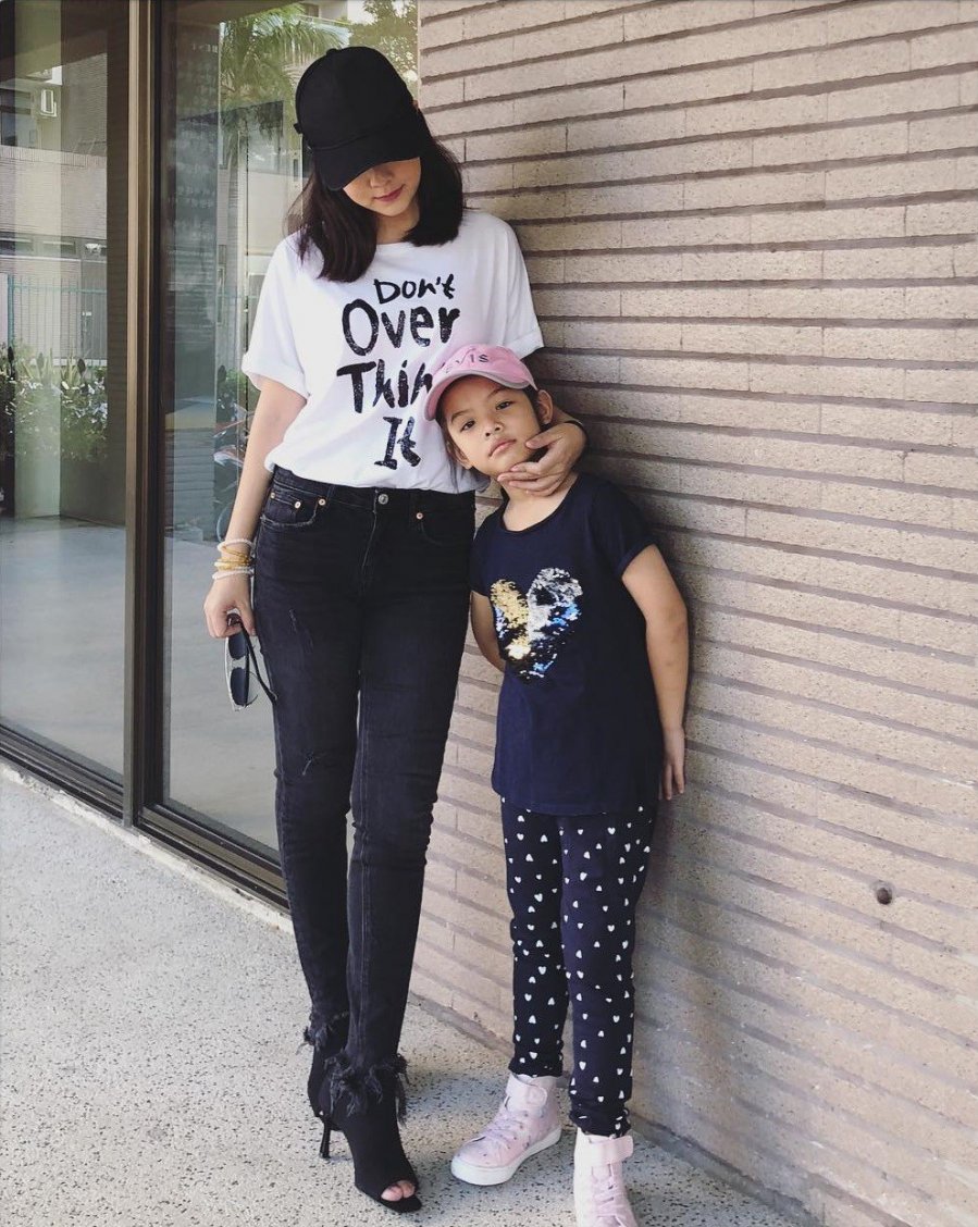  Bà mẹ 2 con thường chọn quần skinny jeans đen giúp tạo hiệu ứng chân nhỏ gọn hơn, mix với áo phông trắng, nhưng nhất định phải in chữ hoặc in hình ấn tượng để vẻ ngoài càng thêm trẻ trung, nổi bật; bên cạnh đó, cô cũng không quên sơ vin giúp tổng thể trang phục thêm sành điệu, tôn dáng. 