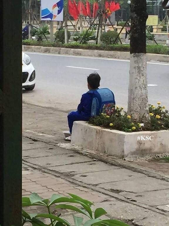Cậu bé thẫn thờ ngồi bán cà chua bên đường.