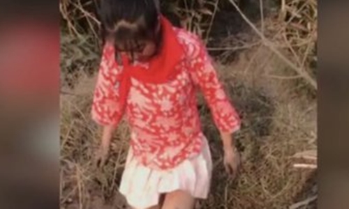 Cô gái đeo khăn quảng đỏ trong video. (Ảnh: Weibo