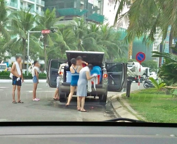 Hình ảnh gia đình dừng ô tô tắm giữa đường ở Đà Nẵng.