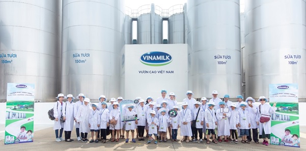 Mọi người chụp ảnh cùng các bồn chứa lạnh khổng lồ, nơi chứa khối lượng lớn sữa tươi nguyên liệu sau khi được vận chuyển từ các trang trại chuẩn GLOBAL G.A.P về nhà máy