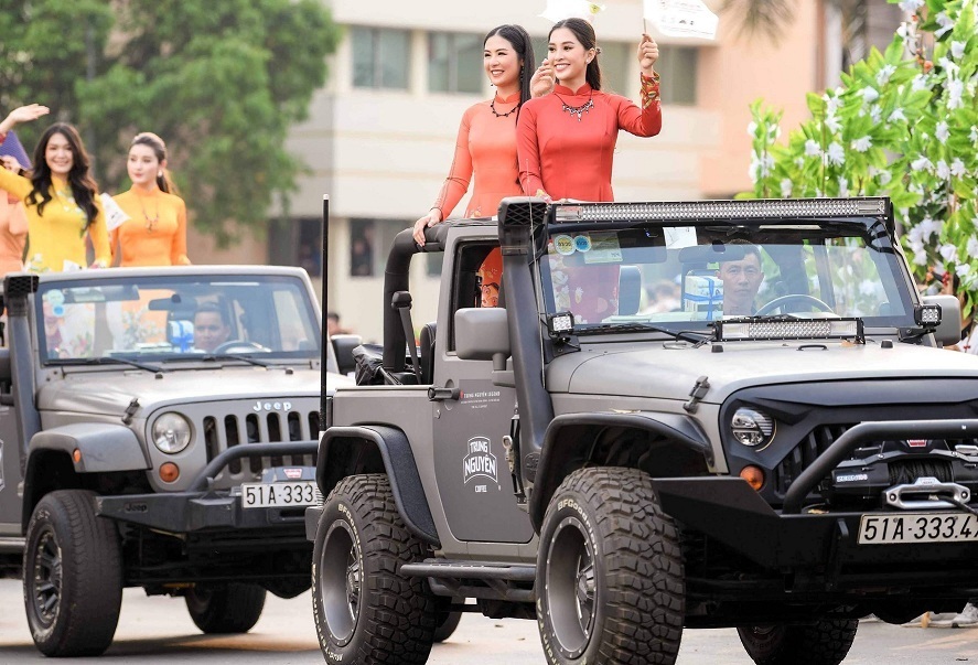 Hai chiếc xe Jeep chở các người đẹp đang di chuyển tại lễ hội cà phê Buôn Ma Thuột 2019.
