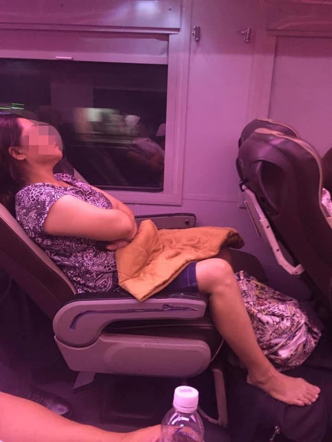Người phụ nữ ngồi ngủ trên tàu không cho người ngồi cạnh di chuyển vào trong.