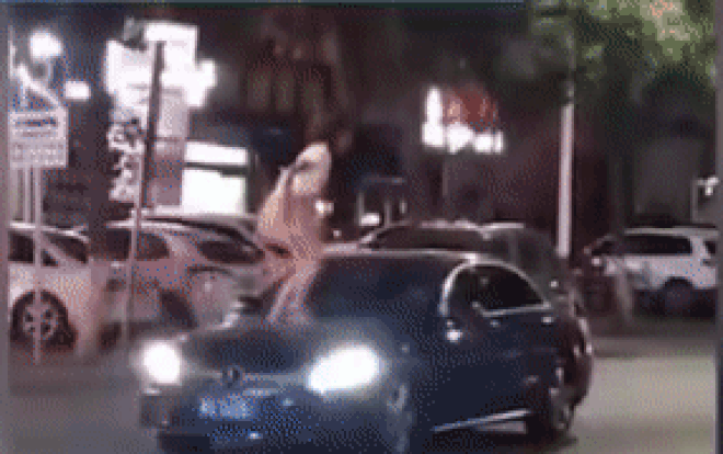 Sau khi trèo lên ô tô thì cô gái này đã đạp vào kính chắn gió và bẻ gương của chiếc xe.