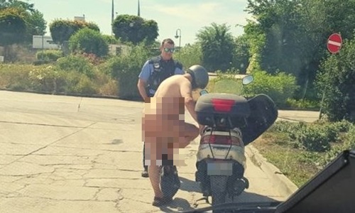 Người đàn ông khỏa thân rồi chạy xe máy trên đường.