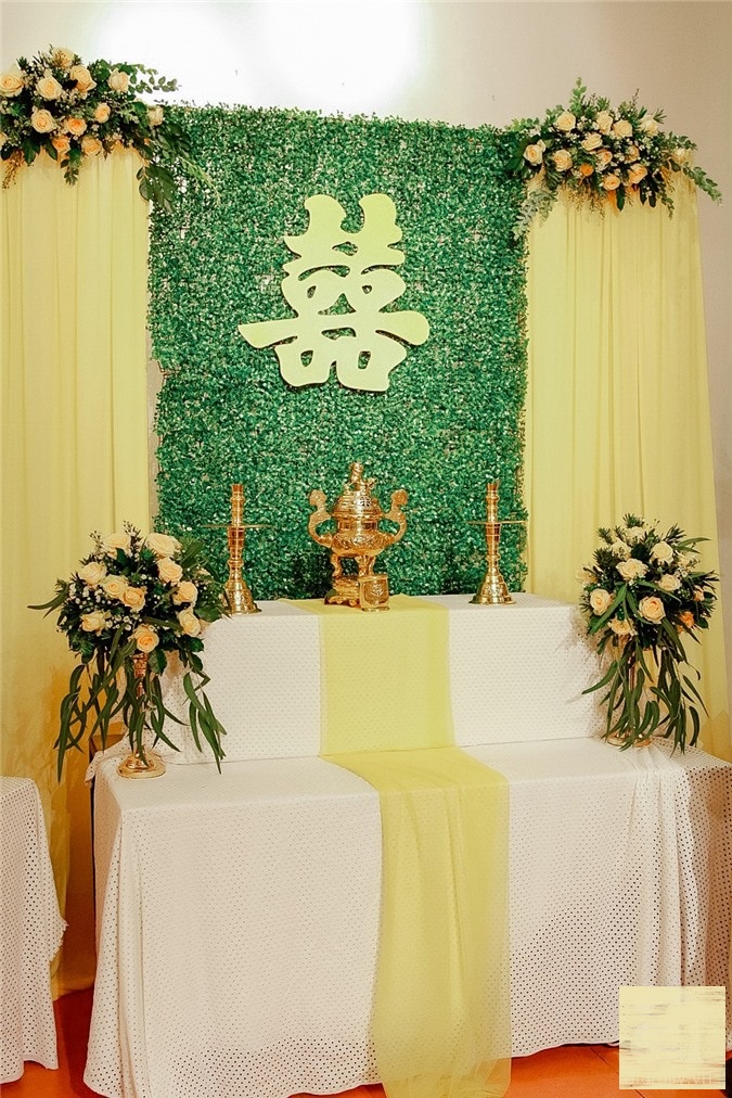 Phông nền hôn trường và bàn làm lễ của cặp đôi theo màu chủ đạo vàng - trắng.