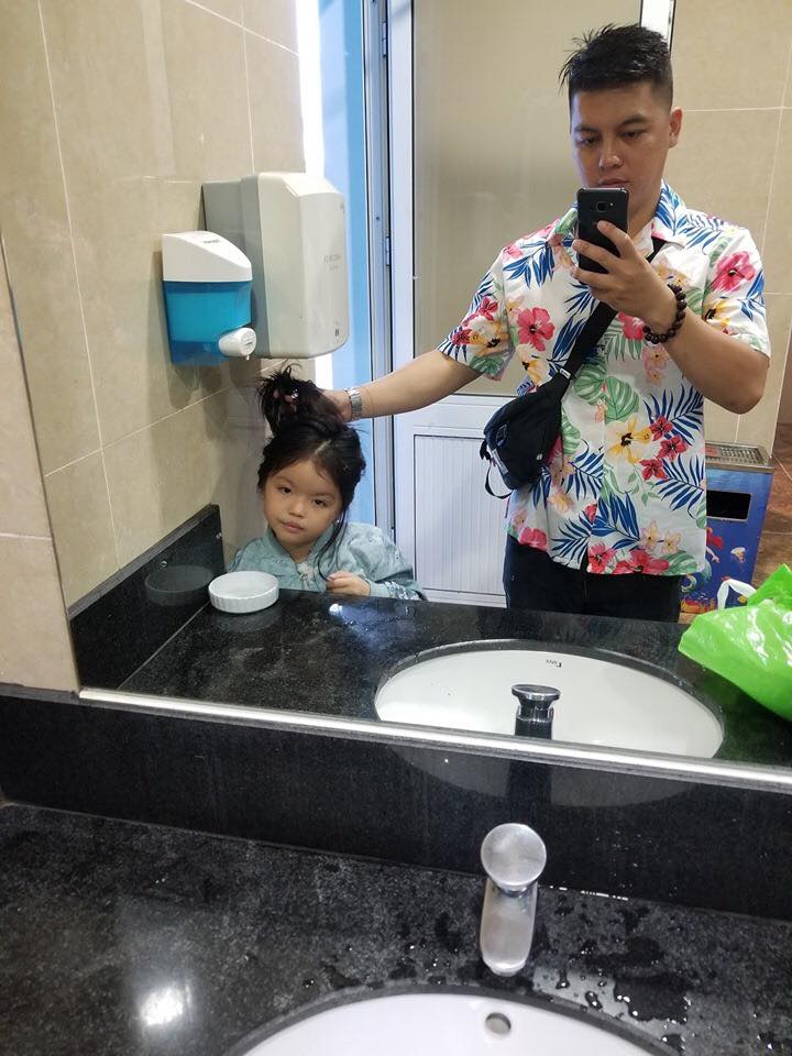 Vừa sấy tóc cho con, ông bố vừa tranh thủ chụp ảnh.