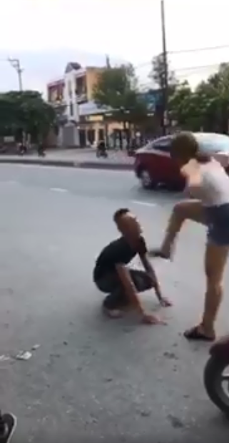 Cô gái đạp vào mặt chàng trai đang quỳ trước mặt.