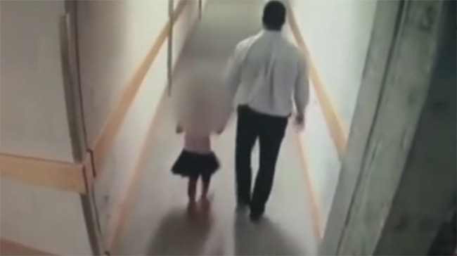 Hình ảnh gã nhân viên an ninh dắt bé gái vào cầu thang thoát hiểm để giở trò sàm sỡ.