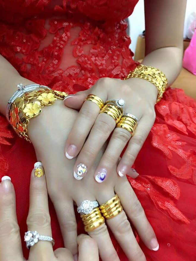 Tay cô dâu cũng được đeo kín bằng nhẫn vàng.