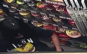 Hình ảnh người phụ nữ trộm đồ ăn trong siêu thị.