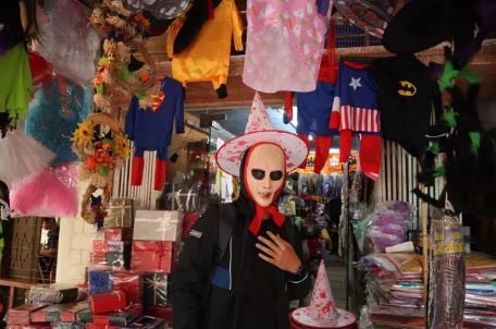 Tại Hà Nội, không khí Halloween cũng vô cùng nhộn nhịp. Trong ảnh là một vị khách nước ngoài đang thử trang phục hóa trang trên phố Hàng Mã. (Ảnh: Gia đình & Xã hội)
