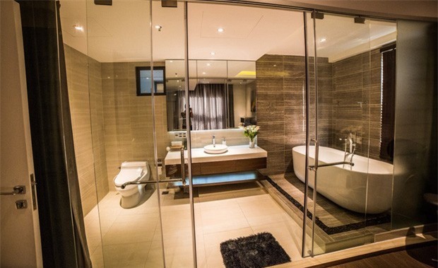 Phòng ngủ hiện đại được trang trí tông màu xám nhạt sang trọng. Phòng tắm với vách ngăn kính lớn tạo cảm giác rộng rãi.    