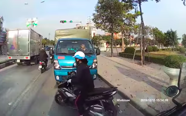 Người phụ nữ đi xe máy đúng chiều phải nhường đường cho tài xế xe tải. Hình ảnh cắt từ clip.