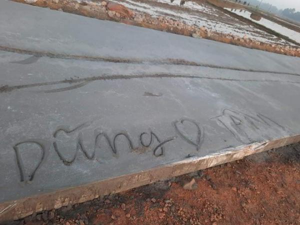 MỘt cặp đôi đã khắc tên mình lên con đường bê tông còn chưa khô.
