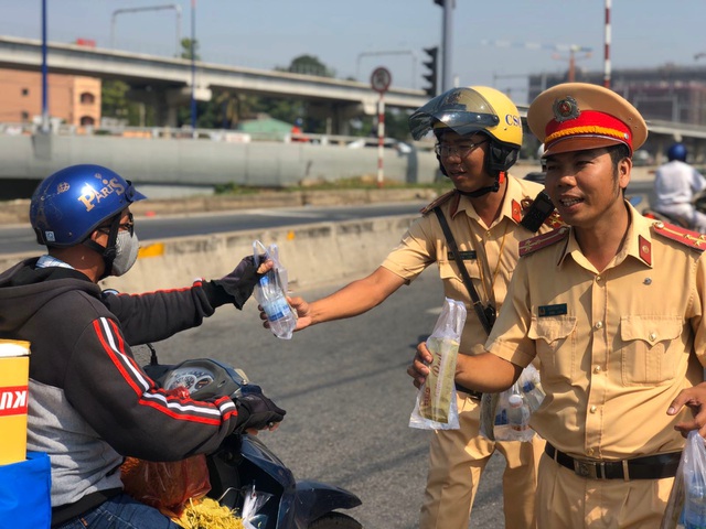 Những người từ Sài Gòn về quê ăn Tết được lực lượng CSGT thành phố tặng nước và khăn lạnh miễn phí.
