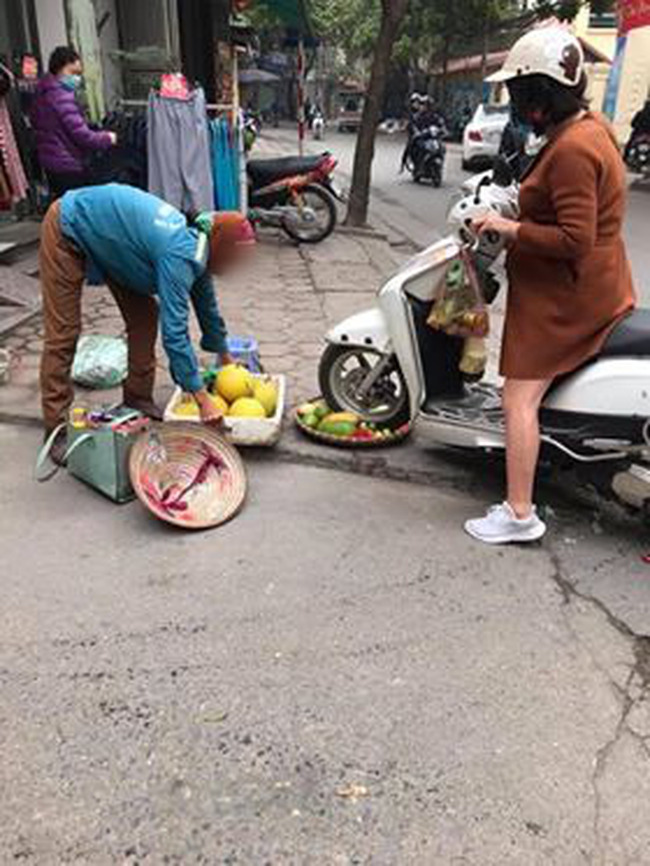 Người phụ nữ trẻ phi thẳng xe vào mẹt hoa quả của người bán hàng rong.