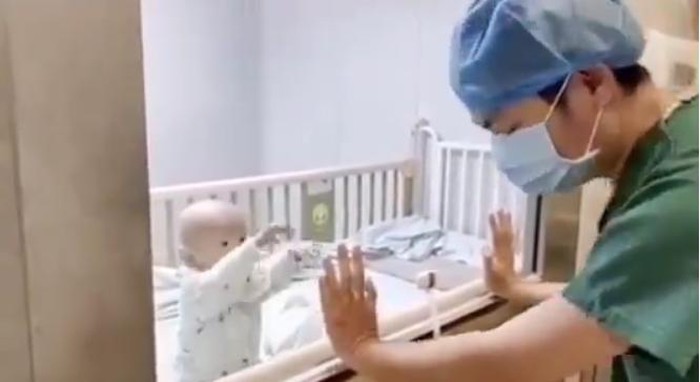Cậu bé 9 tháng tuổi giơ tay đòi bế khi nhìn thấy bố.