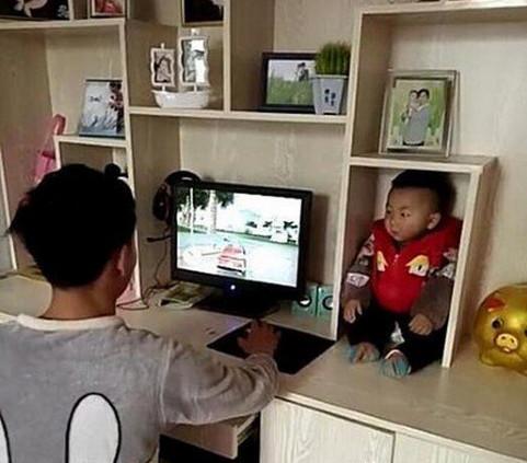 Ông bố đặt con vào một ngăn tủ rồi thản nhiên chơi game.