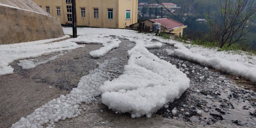 Hình ảnh các hạt mưa đá dày đặc phủ trắng cả tuyến đường.