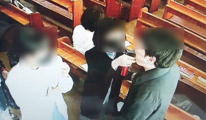 Hình ảnh một người ở nhà thờ xịt nước muối vào miệng tín đồ. Ảnh: Yonhap.