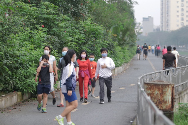 Nhiều người dân vẫn thoải mái đi tập thể dục trên con đường đi bộ dọc bờ sông Tô Lịch. (Ảnh: Dân trí)