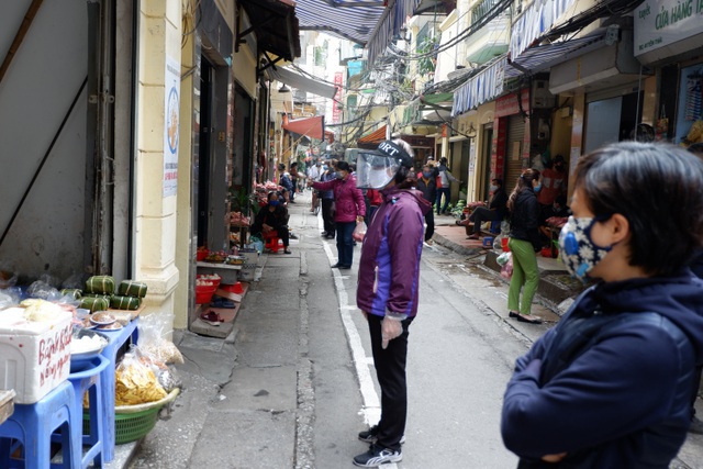 Người đến mua hàng tại phố Yên Thái, Hà Nội chấp hành quy định không vượt qua vạch sơn an toàn (Ảnh Dân Trí)