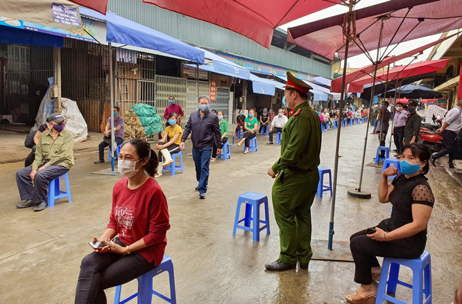 Người dân xếp hàng chờ xét nghiệm nhanh ở chợ Long Biên. Ảnh: Hà Nội mới