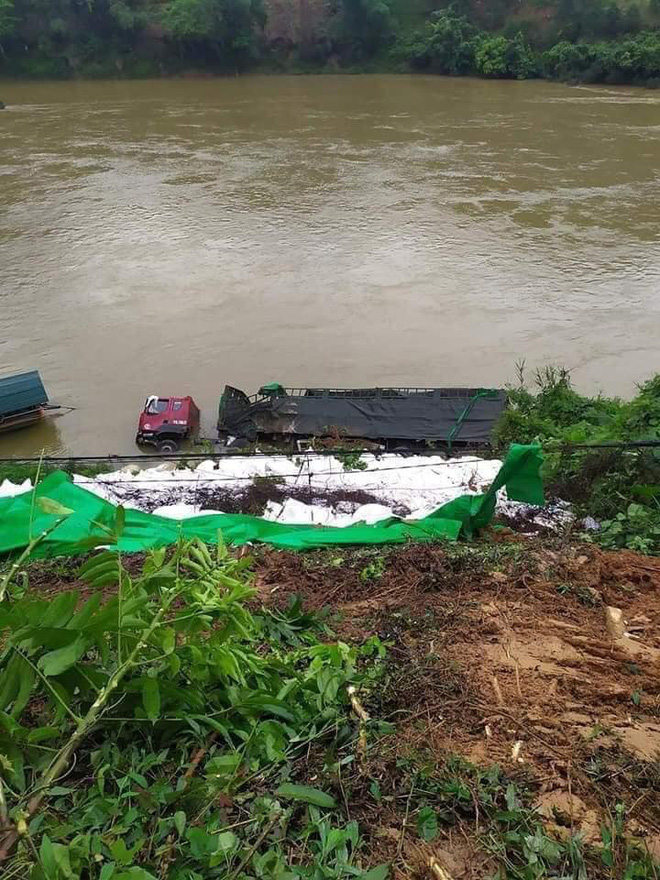 Chiếc xe tải lật nghiêng rơi xuống sông, hàng trăm bao gạo trong thùng xe đã chìm trong nước.