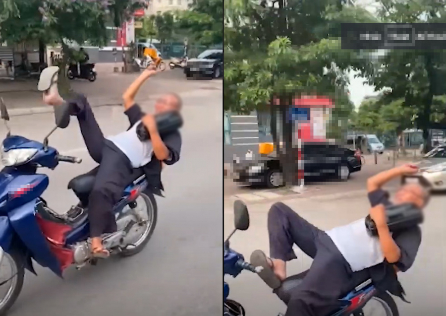 Người đàn ông nằm ngả người ra yên xe máy khi lưu thông trên đường.