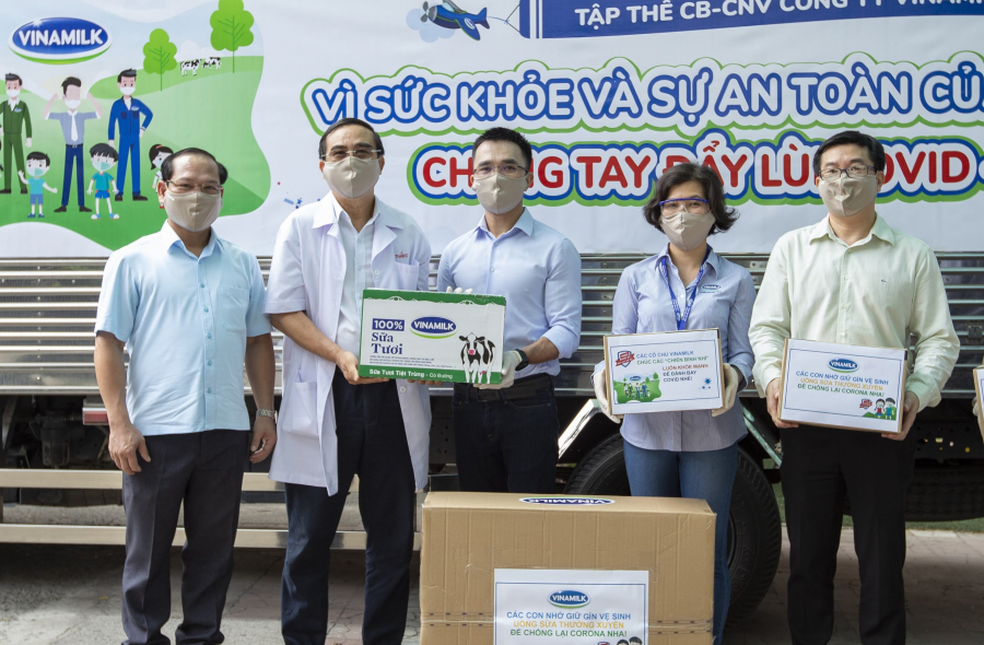 Anh Nguyễn Quang Thái (đứng giữa) đại diện công ty trao tặng sữa cho các trẻ em có hoàn cảnh khó khăn cần giúp đỡ trong dịch Covid-19 vừa qua