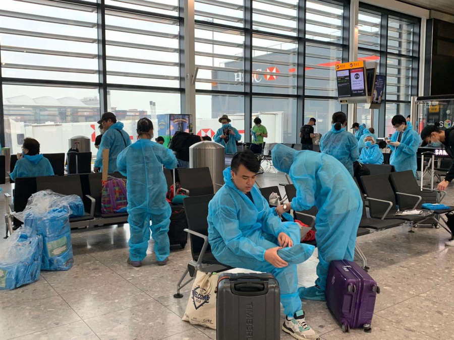 Nhân viên cùng các hành khách của chuyến bay được kiểm tra thân nhiệt và mặc đồ bảo hộ đảm bảo an toàn