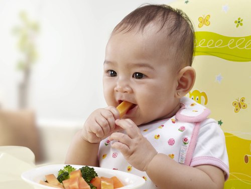 Khi bé bắt đầu ăn dặm, cha mẹ hãy tập cho bé thói quen tự xúc khi ăn.