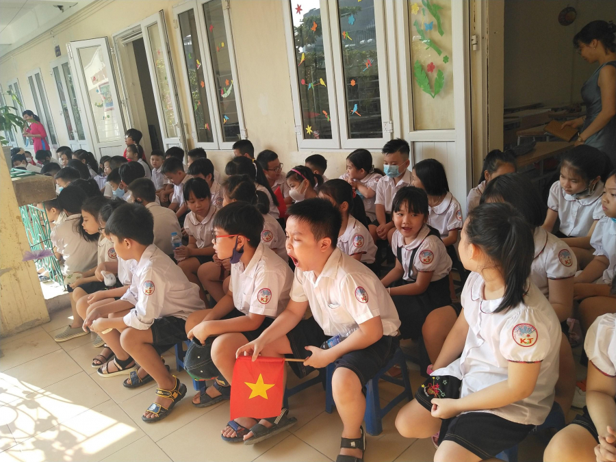 Trường tiểu học Khương Thượng (quận Đống Đa, TP Hà Nội) thực hiện việc giãn cách bằng cách cho các em học sinh ngồi trên hành lang lớp học thay vì tụ tập quá đông dưới sân trường