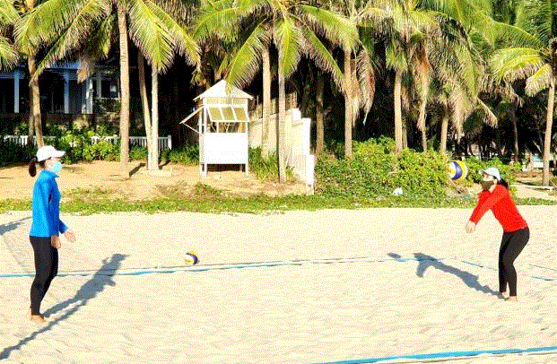 Hai người phụ nữ đánh bóng chuyền trên cát