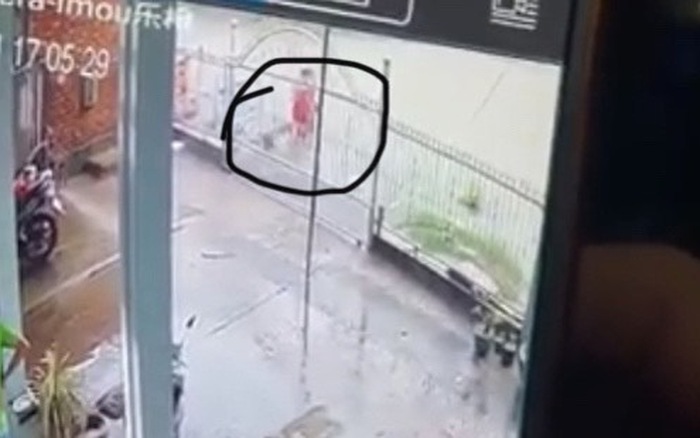 Ảnh cắt từ camera ghi lại cảnh người phụ nữ đi trên đường, bị trượt chân lọt xuống mương nước