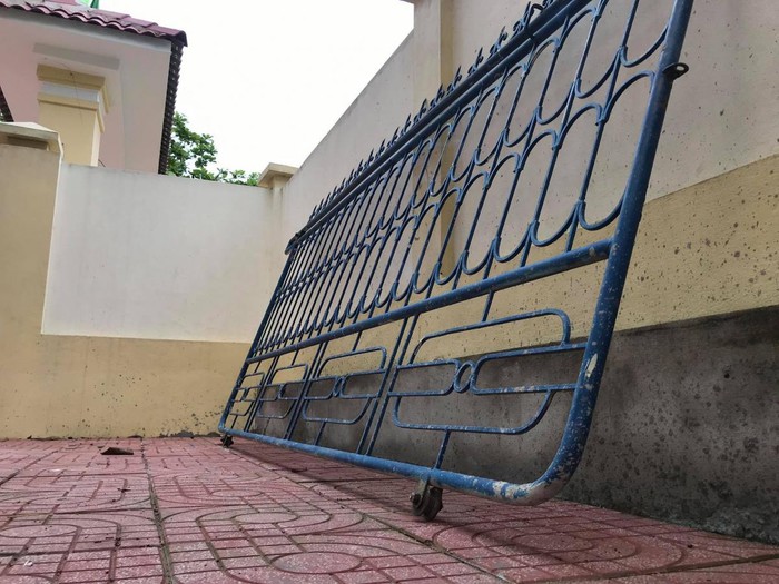 Cánh cổng sắt bị sập đè trúng chân em học sinh