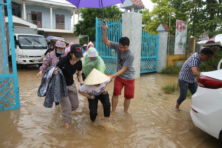 Nữ ca sĩ xắn quần lội nước để đến gần hơn, tự tay trao quà cũng như động viên bà con ở vùng ngập sâu.