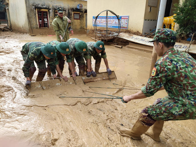 Bộ đội giúp trường dọn bùn đất  (Ảnh: NLĐ)