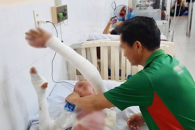 Gia đình thay nhau túc trực bên giường bệnh để chăm sóc cậu bé bị bỏng. Ảnh: Thanh niên