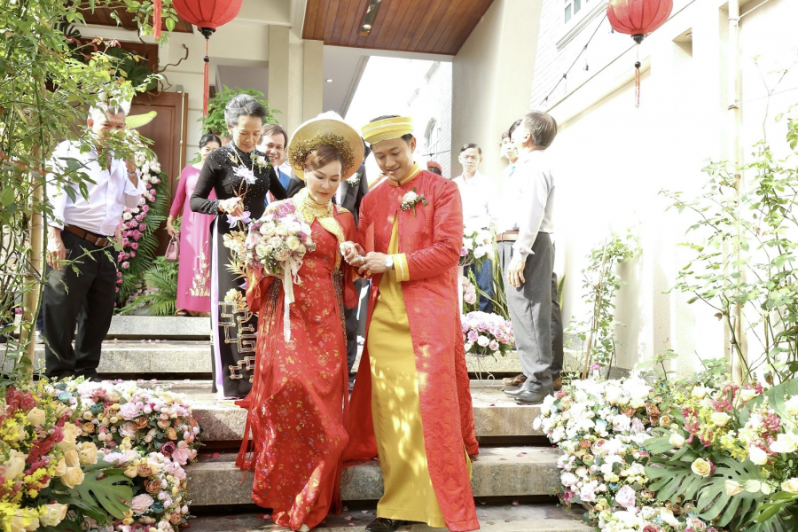 Cô dâu chú rể cùng diện áo dài đỏ sánh đôi trong sự ngưỡng mộ của các khách mời.