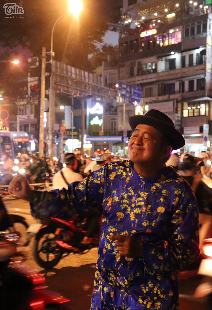 Mặc kệ những ánh mắt dị nghị, chú Ba Chánh vẫn lạc quan, vui tươi nhảy múa và bán bánh (Ảnh: Báo Đất Việt)